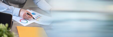 Businessman analysing marketing charts at office; panoramic bannerの写真素材