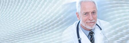Portrait of male senior doctor looking the camera; panoramic bannerの写真素材