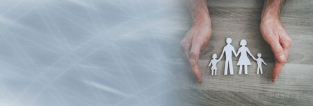 Hands protecting a family; symbol of life insurance; panoramic banner