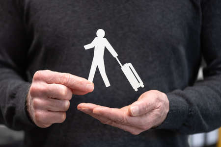 Man holding a paper traveller; Concept of travel insuranceの写真素材