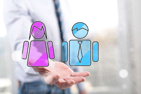Gender equality concept above the hand of a man in backgroundの写真素材