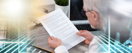 Senior businessman checking document in office; multiple exposure