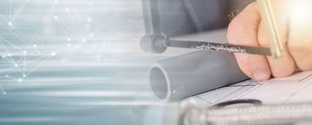 Plumber sawing a pvc pipe, closeup; panoramic banner