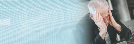 Overworked and exhausted senior businessman sitting at workplace; panoramic bannerの写真素材