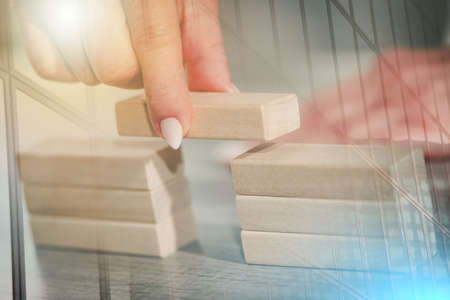 Female hand building a bridge with wooden blocks; concept of association; multiple exposure