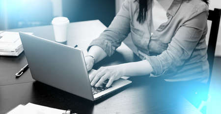 Young attractive businesswoman working on laptop at home; light effect