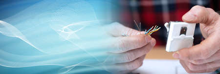 Electrician hands preparing an internet connection; panoramic banner