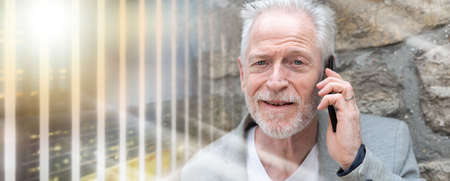 Mature man using his mobile phone outdoors; multiple exposure