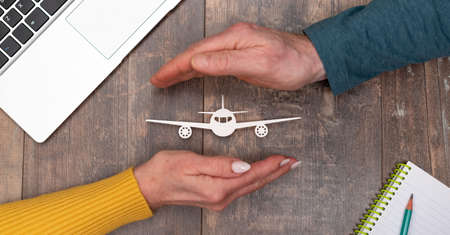 Concept of flight insurance with hands in a protective gestureの写真素材