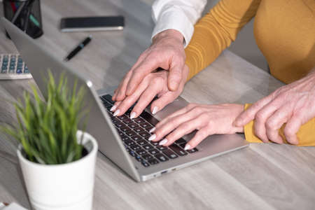 Sexual harassment at work; boss touching hand of secretaryの写真素材