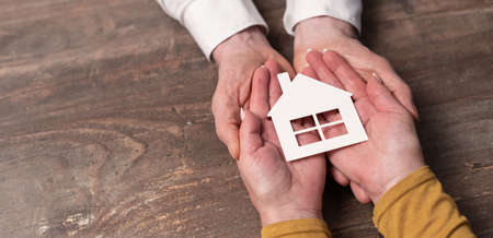 Concept of home insurance with paper house in handsの写真素材