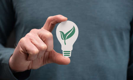 Man holding a paper light bulb; Concept of clean energy