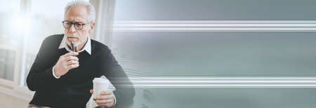 Portrait of thoughtful senior businessman at office; panoramic bannerの写真素材