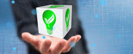 Green energy concept above the hand of a man in background