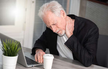 Senior businessman suffering from neck pain
