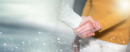 Businesswoman and businessman shaking hands; panoramic banner