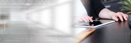 Businesswoman using digital tablet at workplace; panoramic bannerの写真素材