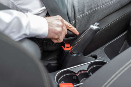 Man fastening seat belt in car