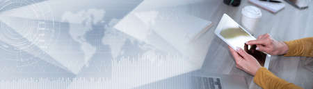 Female hands using digital tablet at workplace; panoramic bannerの写真素材