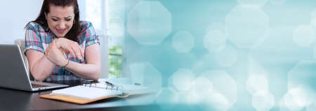 Young businesswoman suffering from wrist pain; panoramic banner