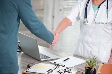 Female doctor shaking hands with her patientの写真素材