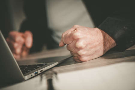 Angry businessman hitting his desk with his clenched fists