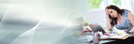 Overworked young businesswoman sitting at a messy desk; panoramic banner