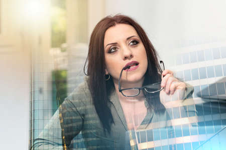 Portrait of young thoughtful businesswoman looking up; multiple exposureの写真素材