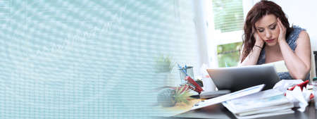 Overworked young businesswoman sitting at a messy desk; panoramic banner