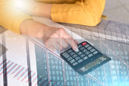 Hands of an accountant working on financial documents and using a calculator; multiple exposure
