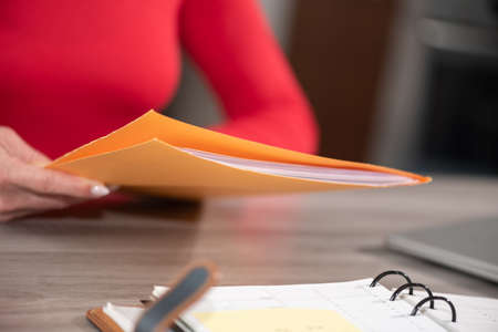 Businesswoman holding folder with paper documents