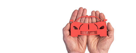 Concept of sports car insurance with paper sports car in hands isolated on white