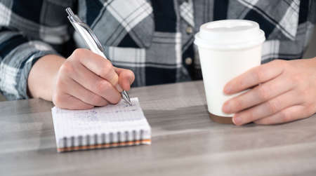 Female hands taking notes on notepad