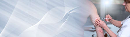 Female doctor injecting vaccine in arm of patient; panoramic bannerの写真素材