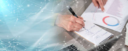 Businesswoman analyzing marketing data and taking notes; panoramic banner