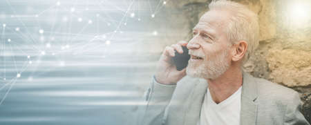 Mature man using his mobile phone outdoors; panoramic bannerの写真素材