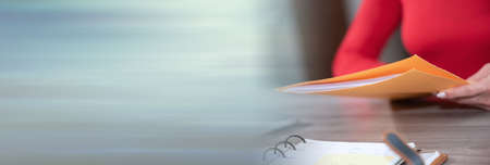 Businesswoman holding folder with paper documents; panoramic banner