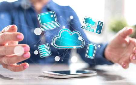 Smartphone with cloud computing concept between hands of a woman in background