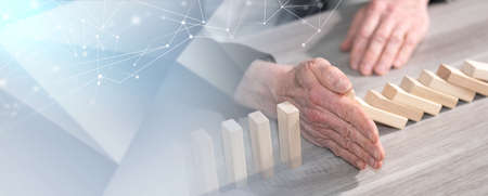 Male hand stopping domino effect. concept of business control; panoramic banner