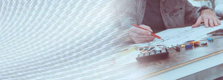 Architect working on plans at office; panoramic banner