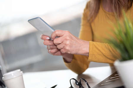 Woman holding and using her mobile phone