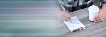 Female hands taking notes on notepad; panoramic bannerの写真素材