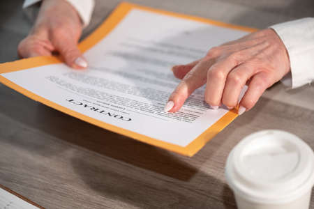 Female hands checking content of a contract