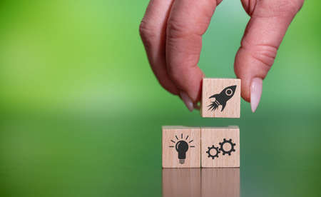 Concept of business start-up with icons on wooden cubes