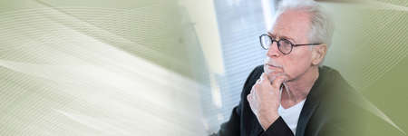 Portrait of thoughtful senior businessman with hand on chin panoramic banner