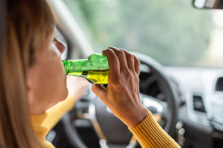 Woman drinking alcohol while driving
