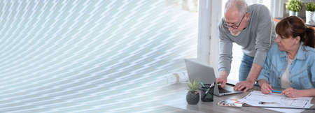 Architects working on new construction project and using laptop; panoramic banner
