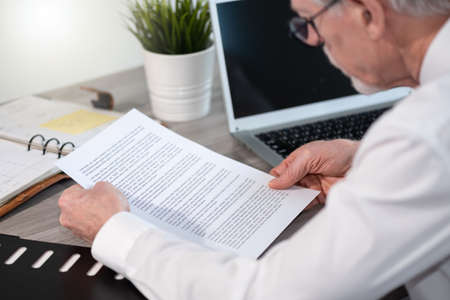 Senior businessman checking document in office