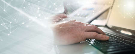 Businessman typing on a laptop at office; panoramic bannerの写真素材