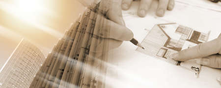 Client showing a detail on house plan to her architect; multiple exposure